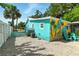 Colorful home with turquoise exterior, delightful mural, and well-kept gravel backyard at 318 Palm St, New Smyrna Beach, FL 32168