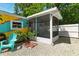 Cozy home featuring a screened patio, vibrant exterior mural, and tidy gravel landscaping at 318 Palm St, New Smyrna Beach, FL 32168