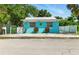 Charming bright blue single-story home with a metal roof and decorative accents at 318 Palm St, New Smyrna Beach, FL 32168