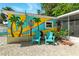 Charming home with colorful mural, bright chairs, and well-maintained gravel landscaping at 318 Palm St, New Smyrna Beach, FL 32168