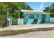 Charming bright blue single-story home with a metal roof and decorative accents at 318 Palm St, New Smyrna Beach, FL 32168