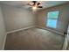 Bedroom featuring a ceiling fan, window, and neutral-colored walls and carpet at 358 2Nd St, Geneva, FL 32732