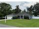 Beautiful home with green lawn and mature trees under a cloudy sky at 358 2Nd St, Geneva, FL 32732