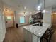 Open kitchen with marble countertop island, stainless steel appliances and wood tile flooring at 358 2Nd St, Geneva, FL 32732