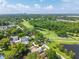 Aerial view of a house near a golf course with lakes and lush greenery, with the city skyline in the distance at 3637 Dubsdread Cir, Orlando, FL 32804