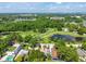 Aerial view of home near golf course surrounded by mature trees and lush greenery at 3637 Dubsdread Cir, Orlando, FL 32804