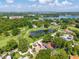 Aerial view of house located near golf course and pond with mature trees and lush green landscape at 3637 Dubsdread Cir, Orlando, FL 32804