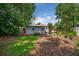 Cozy backyard featuring mulch, lush trees, and a charming cottage-style home at 3637 Dubsdread Cir, Orlando, FL 32804