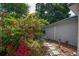 Landscaped backyard featuring a lush bougainvillea bush, stepping stones and well-kept grass at 3637 Dubsdread Cir, Orlando, FL 32804