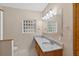 Bathroom featuring dual sinks with granite countertops, a decorative glass block window, and vanity lights above a large mirror at 3637 Dubsdread Cir, Orlando, FL 32804