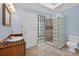Bright bathroom with glass block shower, ceramic tile floors, and a door to the exterior at 3637 Dubsdread Cir, Orlando, FL 32804