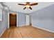 Bedroom with wood floors, ceiling fan and closet with bi-fold doors at 3637 Dubsdread Cir, Orlando, FL 32804