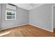 Bright bedroom featuring hardwood floors, a ceiling fan, an AC unit, and a window letting in natural light at 3637 Dubsdread Cir, Orlando, FL 32804