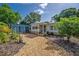 Quaint single-Gathering home featuring neutral siding, stone accents, and a detached blue carport at 3637 Dubsdread Cir, Orlando, FL 32804