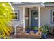 Charming home featuring a brick facade and a welcoming blue front door with decorative hanging plants at 3637 Dubsdread Cir, Orlando, FL 32804