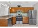 Well-equipped kitchen featuring wood cabinets, stainless steel appliances, and tiled backsplash at 3637 Dubsdread Cir, Orlando, FL 32804
