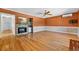 Spacious living room featuring gleaming hardwood floors, a fireplace, and a vintage ceiling fan at 3637 Dubsdread Cir, Orlando, FL 32804