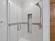 Modern glass shower featuring tiled walls with a decorative accent border, built-in shelves, and a shower head at 3637 Dubsdread Cir, Orlando, FL 32804