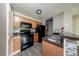 Charming kitchen featuring wood cabinets, stone countertops, black appliances, and backsplash at 420 Forestway Cir # 306, Altamonte Springs, FL 32701