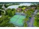 Aerial view of the community tennis courts surrounded by trees, lake, and buildings at 420 Forestway Cir # 306, Altamonte Springs, FL 32701