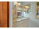 Bright bathroom featuring granite countertops, dual mirrors and views from the window at 4365 S Atlantic Ave # B8, New Smyrna Beach, FL 32169