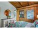 Cozy bedroom with wooden walls, ensuite bathroom, and unique round mirror at 4365 S Atlantic Ave # B8, New Smyrna Beach, FL 32169