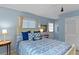 Serene bedroom featuring blue accents, a comfortable bed with decorative pillows, and a door leading to outdoor access at 4365 S Atlantic Ave # B8, New Smyrna Beach, FL 32169