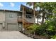 Inviting two-story home with a charming wooden staircase and lush tropical landscaping at 4365 S Atlantic Ave # B8, New Smyrna Beach, FL 32169