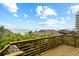 Deck offers scenic ocean views with lush greenery below under a blue cloudy sky at 4365 S Atlantic Ave # B8, New Smyrna Beach, FL 32169