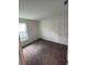 A bright bedroom featuring neutral walls, carpet flooring, and a large window for ample natural light at 4624 Via Veneto Ct, Kissimmee, FL 34746
