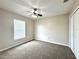 A bright bedroom features neutral carpet and walls, ceiling fan, a closet and natural light from the window at 468 Rio Grande Ct, Kissimmee, FL 34759