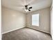 A cozy bedroom features neutral carpet and walls, ceiling fan, and natural light from the window at 468 Rio Grande Ct, Kissimmee, FL 34759