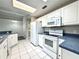 Kitchen with white appliances, white cabinetry, tiled floors, and a skylight providing bright natural light at 468 Rio Grande Ct, Kissimmee, FL 34759