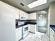 Kitchen with white appliances, white cabinetry, tiled floors, and a skylight providing bright natural light at 468 Rio Grande Ct, Kissimmee, FL 34759