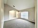 Bright living room featuring neutral paint, carpet flooring and a large window letting in natural light at 468 Rio Grande Ct, Kissimmee, FL 34759