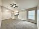 Spacious carpeted living room featuring a ceiling fan and an adjacent kitchen area at 468 Rio Grande Ct, Kissimmee, FL 34759