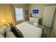 Bedroom includes tiled floor, television, and comfortable queen-sized bed at 4700 Prairie Point Blvd, Kissimmee, FL 34746