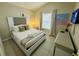 Well-lit bedroom with decorative pillows, tiled floor and neutral color palette at 4700 Prairie Point Blvd, Kissimmee, FL 34746