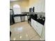 Bright kitchen features white cabinetry, stainless steel appliances, and black countertops at 4700 Prairie Point Blvd, Kissimmee, FL 34746