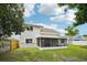 Rear exterior with a screened lanai and a view of the grassy backyard, offering privacy and space at 478 Chicago Woods Cir, Orlando, FL 32824