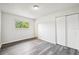Light-filled bedroom featuring wood-look floors and a double closet at 478 Chicago Woods Cir, Orlando, FL 32824