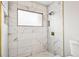 Tiled shower with marble accents and a frosted window at 478 Chicago Woods Cir, Orlando, FL 32824