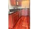 Well-lit kitchen featuring cherry wood cabinets, black granite countertops, and stainless steel appliances at 4830 S Conway Rd # 40, Orlando, FL 32812