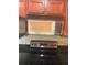 Cherry wood cabinets are featured above an electric stove and a stainless steel microwave at 4830 S Conway Rd # 40, Orlando, FL 32812