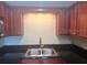 The kitchen features a double sink and wooden cabinets at 4830 S Conway Rd # 40, Orlando, FL 32812