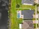 Aerial view of a backyard with a swimming pool and patio near a pond at 4993 Southlawn Ave, Orlando, FL 32811