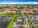 A home with a spacious backyard with a pool and a view of the pond, near other houses in a community at 4993 Southlawn Ave, Orlando, FL 32811