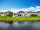 A home with a spacious backyard with a view of the pond, black metal fence and white vinyl fence at 4993 Southlawn Ave, Orlando, FL 32811