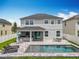 A backyard swimming pool with an outdoor kitchen and patio set, enclosed with a white vinyl fence at 4993 Southlawn Ave, Orlando, FL 32811