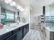 Bathroom with double vanity, stylish cabinets, tub, and storage, brightened by natural light at 4993 Southlawn Ave, Orlando, FL 32811